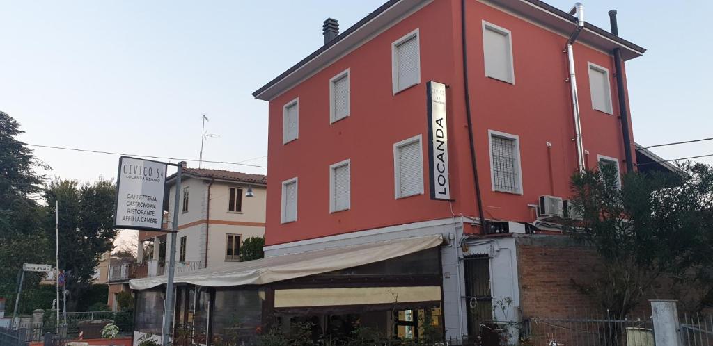 a red building on the side of a street at Civico 54 - Locanda & Bistrò in Nonantola