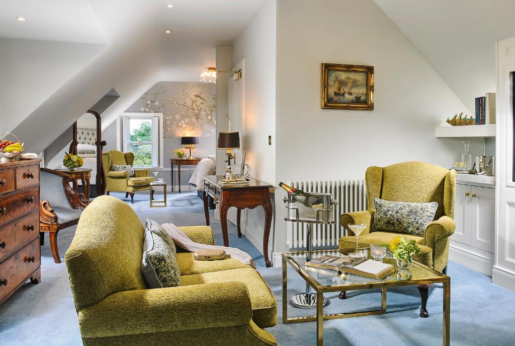 a living room with yellow chairs and a table at Killarney Randles Hotel in Killarney