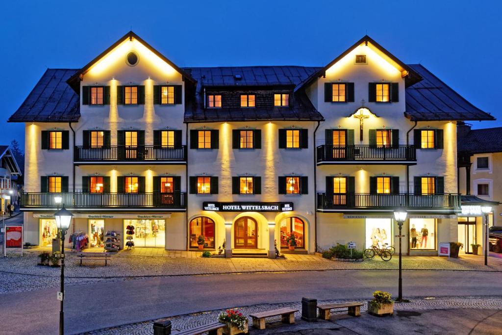 ein großes weißes Gebäude mit Licht an in der Unterkunft Hotel Wittelsbach Oberammergau in Oberammergau