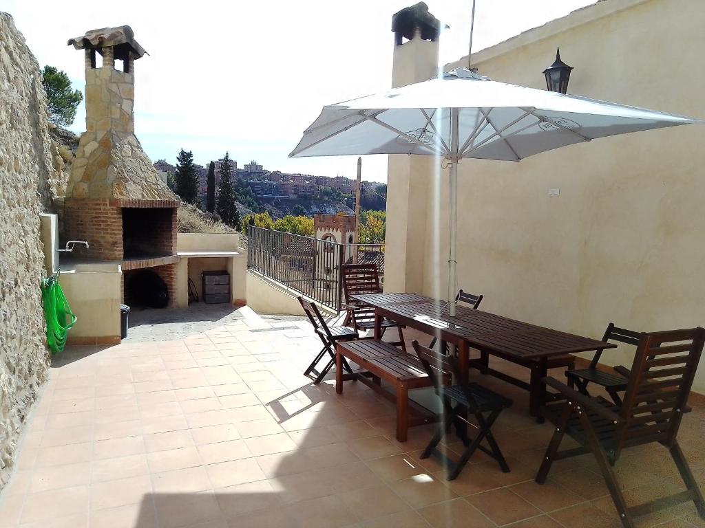 een tafel en stoelen met een parasol op een patio bij LAGAR DEL PALOMAR in Teruel