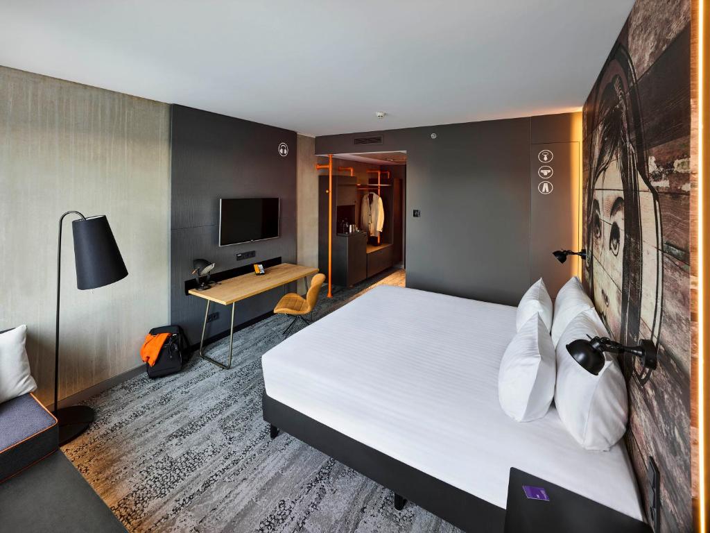 アムステルダムにあるJaz in the City Amsterdamのベッドと机があるホテルの部屋