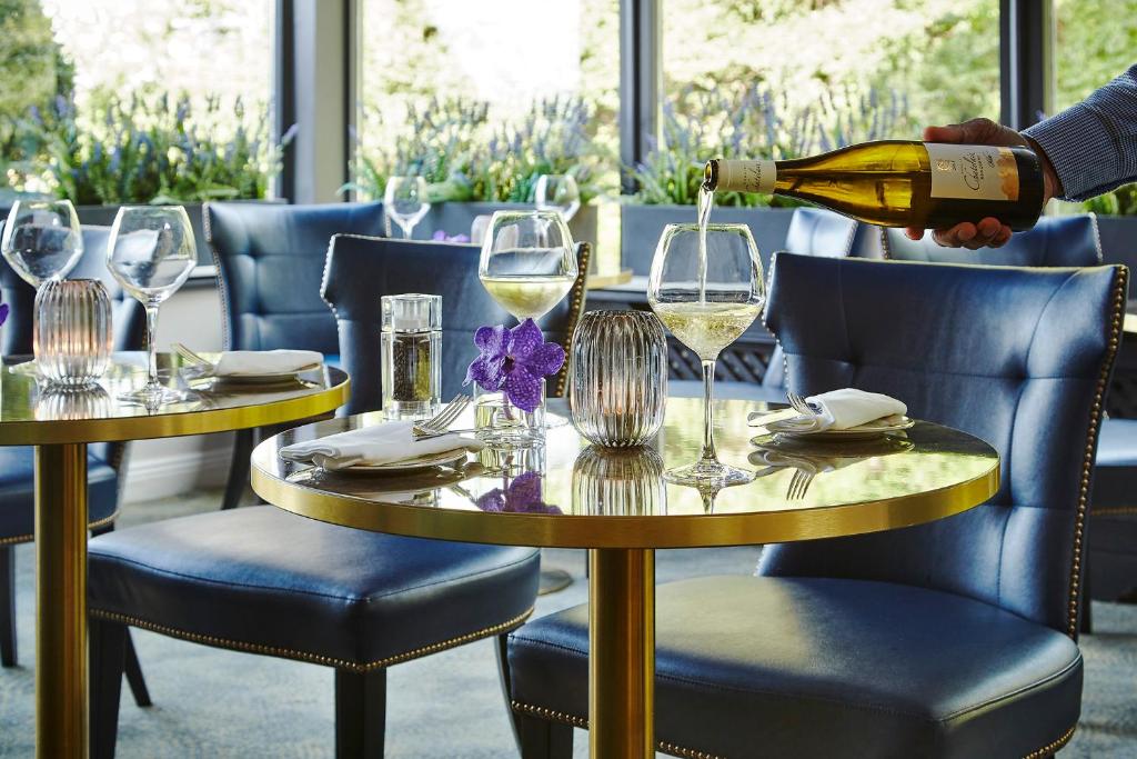 a person is pouring white wine into glasses on a table at Killarney Randles Hotel in Killarney