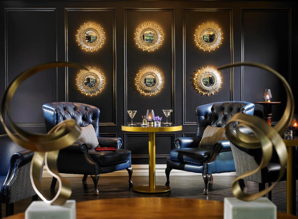 a room with two chairs and a table and mirrors at Killarney Randles Hotel in Killarney