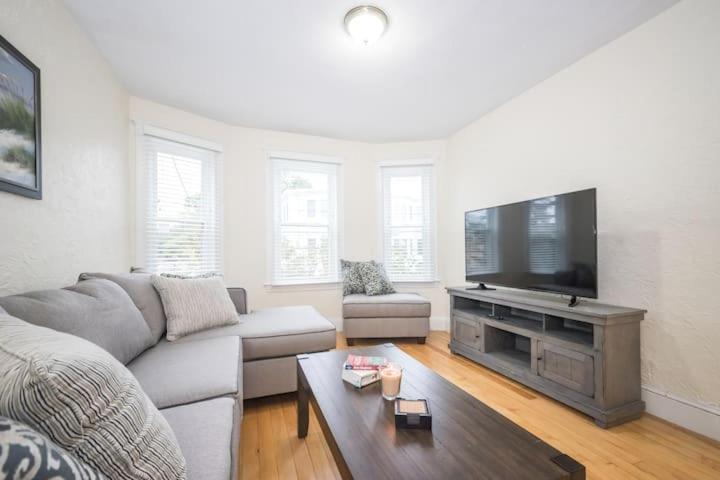 a living room with a couch and a flat screen tv at The Boston Rental - Multiple Floorplans in Boston