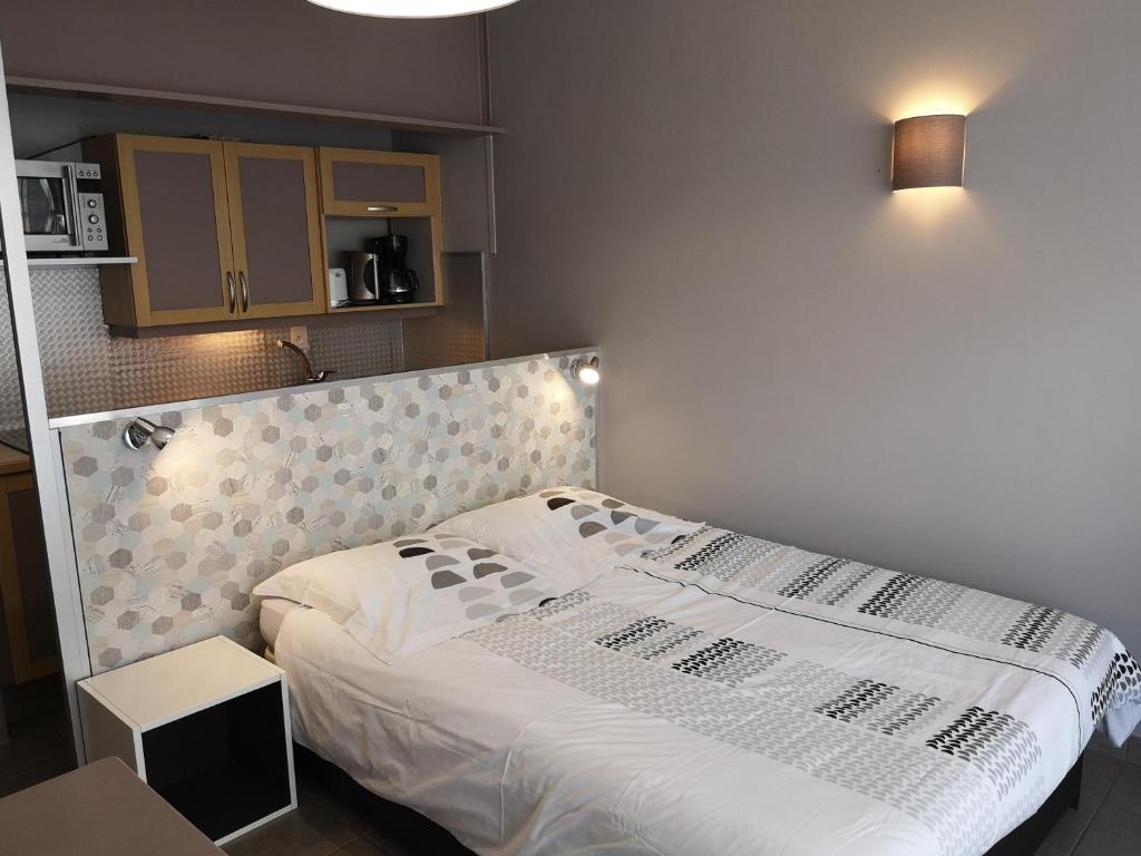 a bedroom with a bed with a white comforter at Le Majestic 106 in Aix-les-Bains