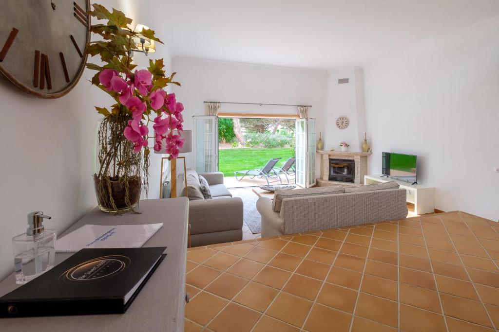 uma sala de estar com um sofá e uma mesa em Vila dos Principes em Casal da Lagoa Seca