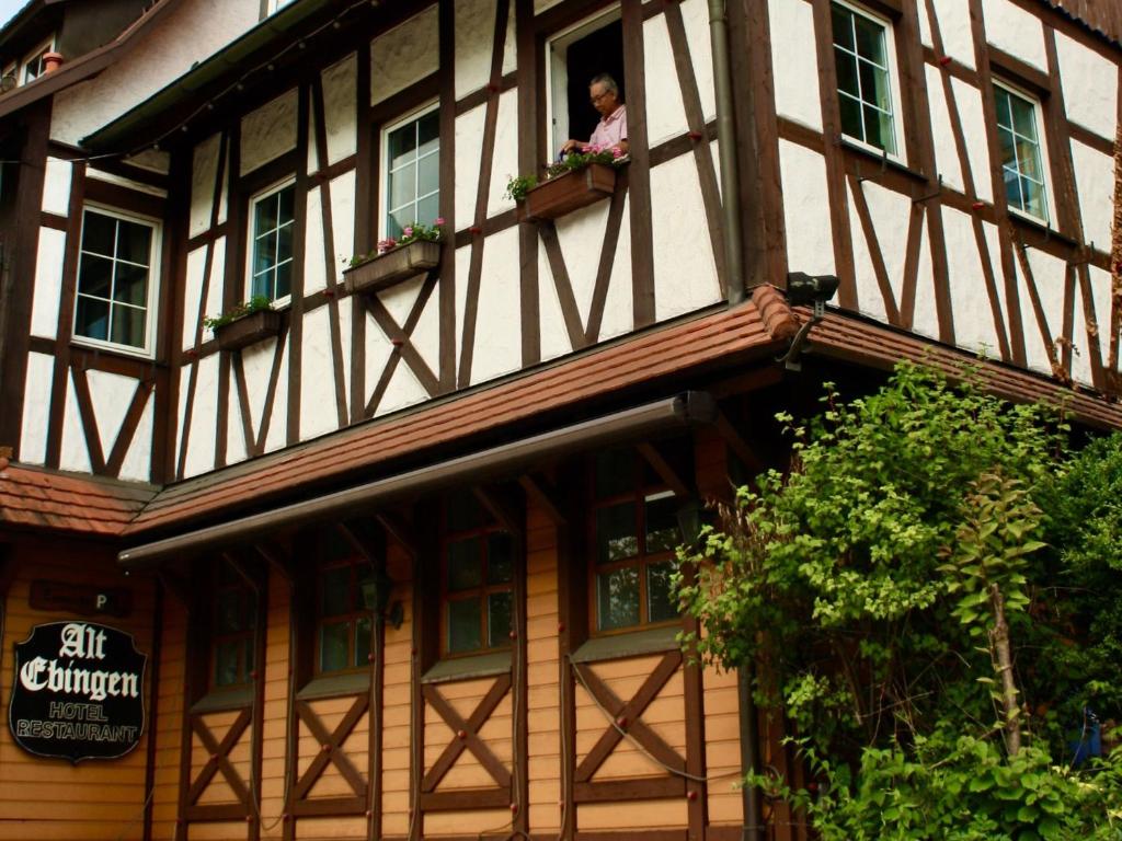 Eine Frau, die aus einem Fenster eines Gebäudes schaut. in der Unterkunft Hotel Alt Ebingen in Albstadt