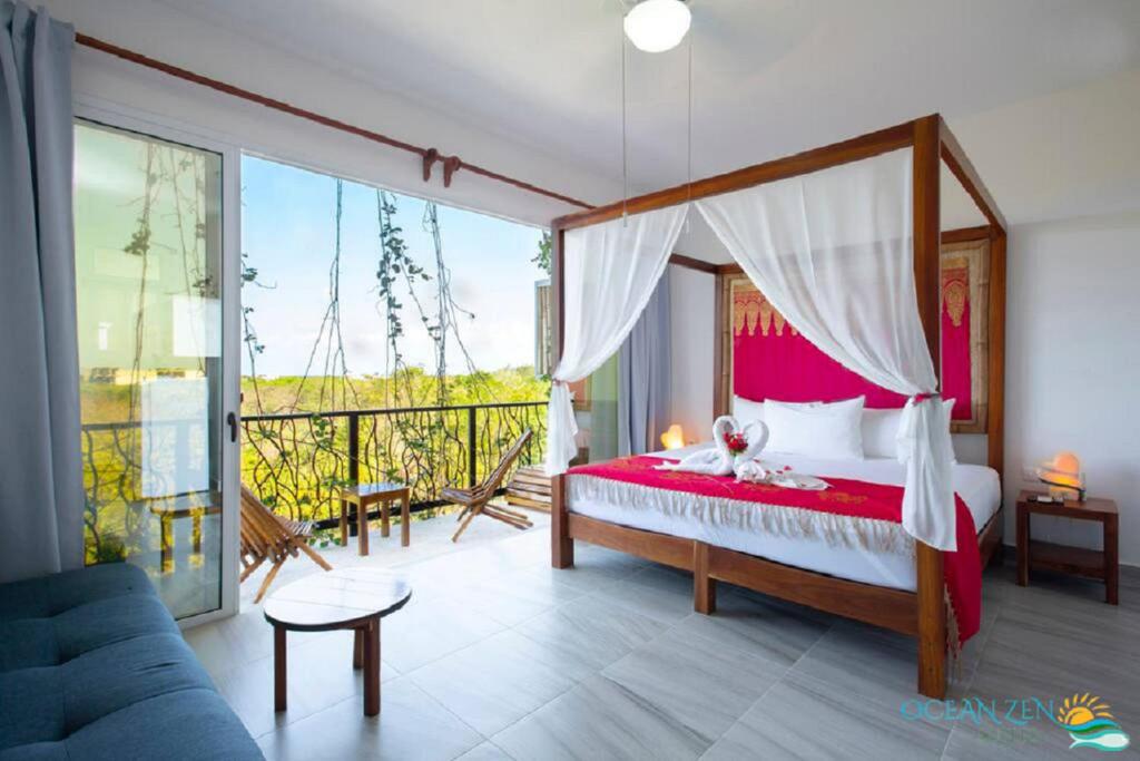 um quarto com uma cama de dossel e uma varanda em Ocean Zen Suites on 5th Avenue - Adults Only em Playa del Carmen