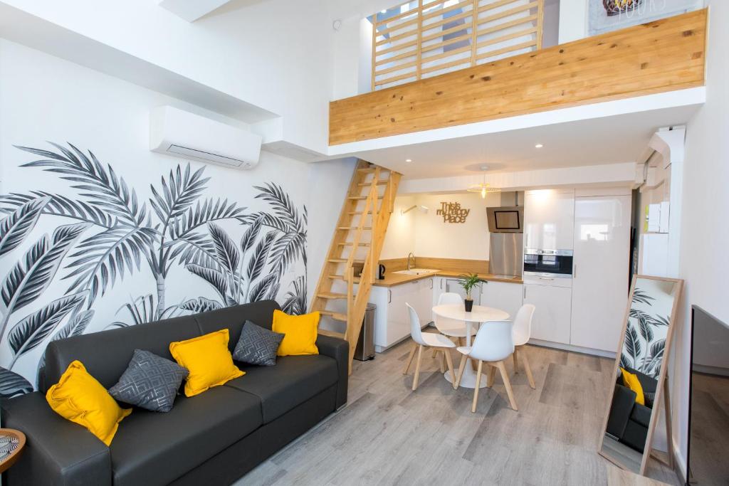 - un salon avec un canapé noir et des oreillers jaunes dans l'établissement Duplex : Plage 300m, Clim, Netflix, à Cannes