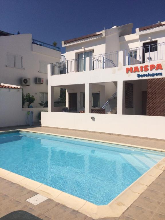 une villa avec une piscine en face d'une maison dans l'établissement Andromeda Beach house, à Pólis Chrysochoús