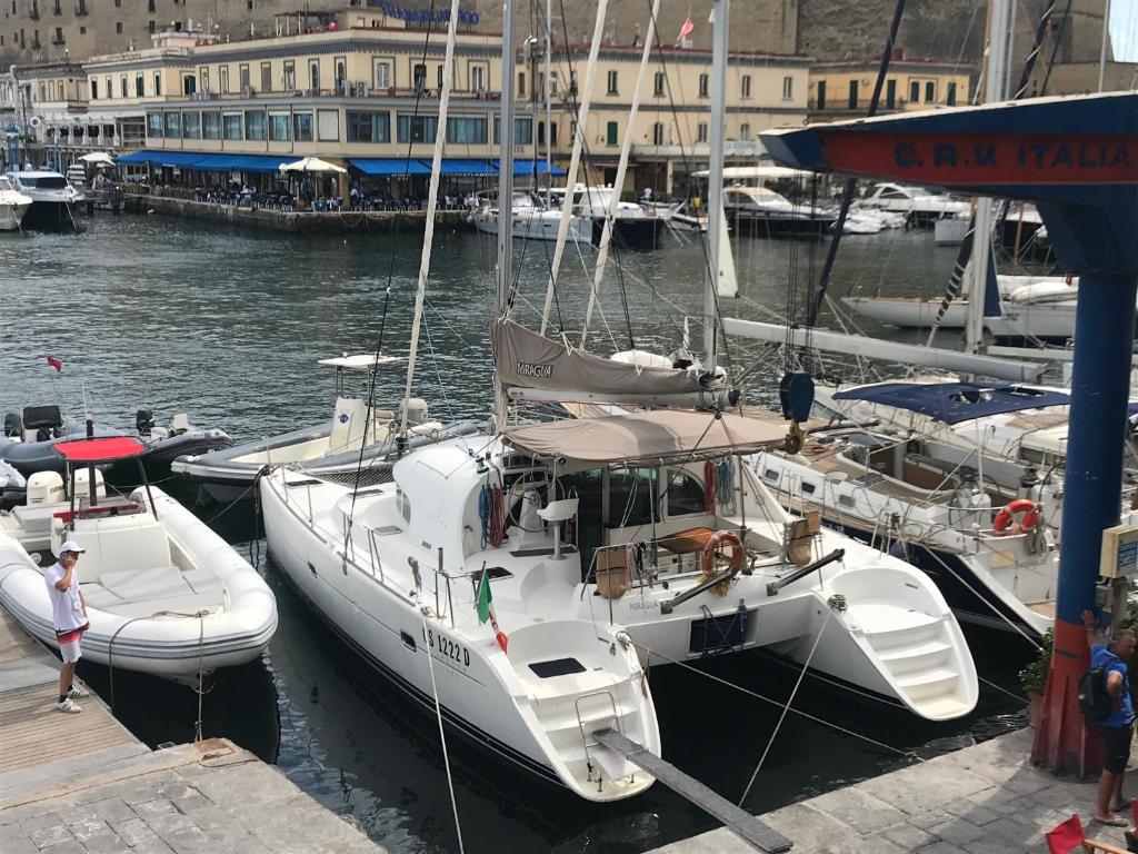 a couple of boats docked in a harbor at Catamarano Miragua - Resort on board in Catania in Catania