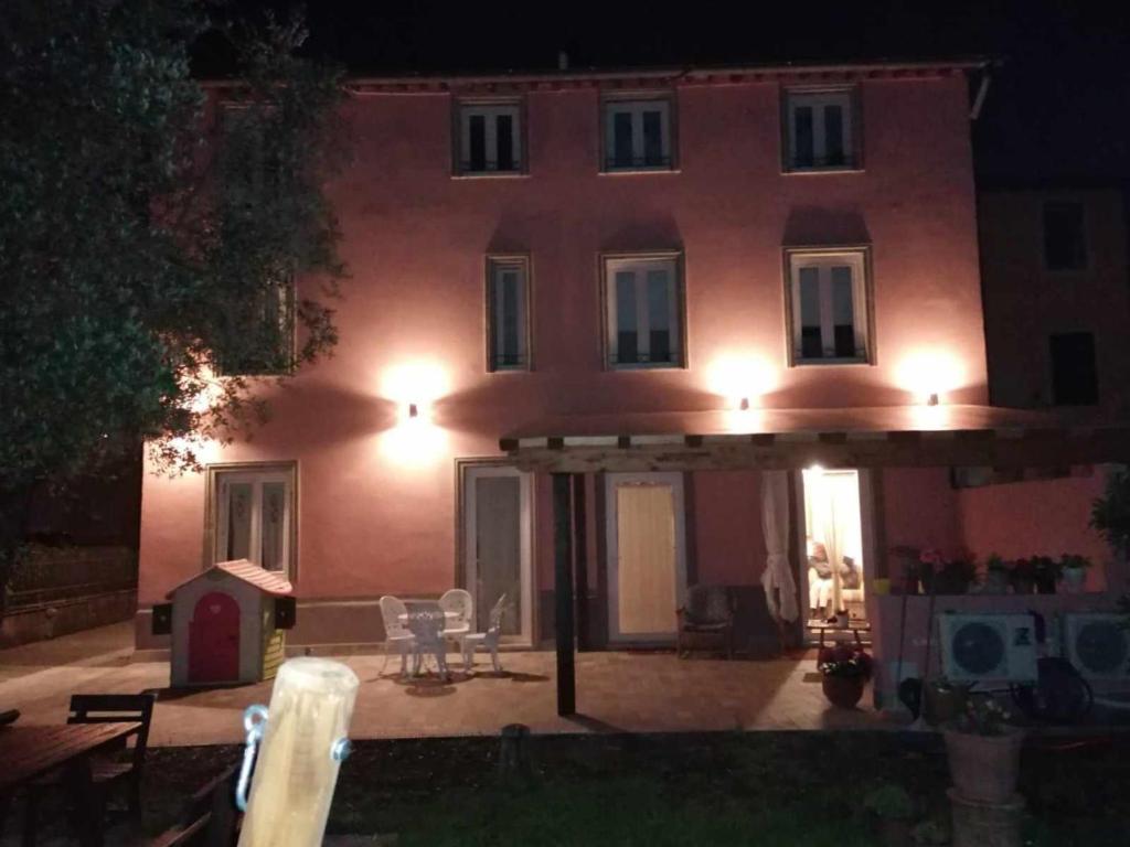 a large pink house with a patio at night at BeB La Rosa Nel Verde in Lucca