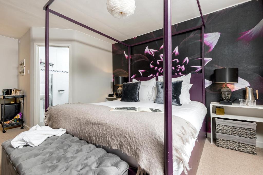 um quarto com uma cama grande com uma estrutura roxa em Crazy Fox Hurley Boutique B&B em Marlow