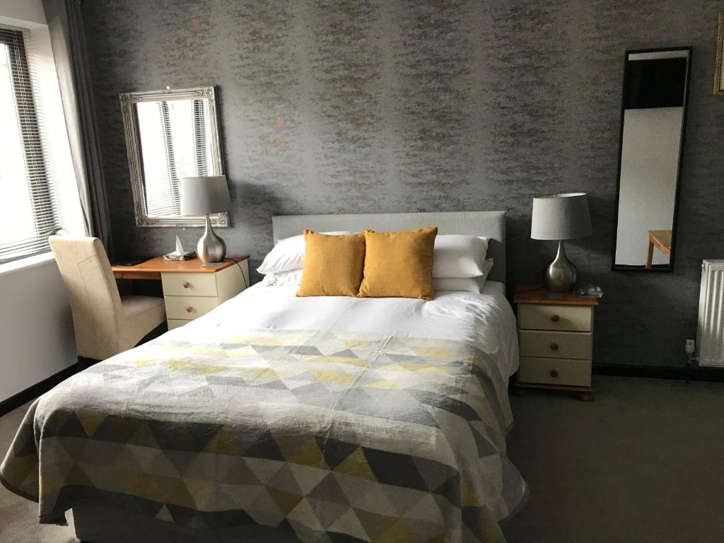1 dormitorio con 1 cama, 2 mesas y 2 lámparas en Rooms @ Number Six, en Oakham