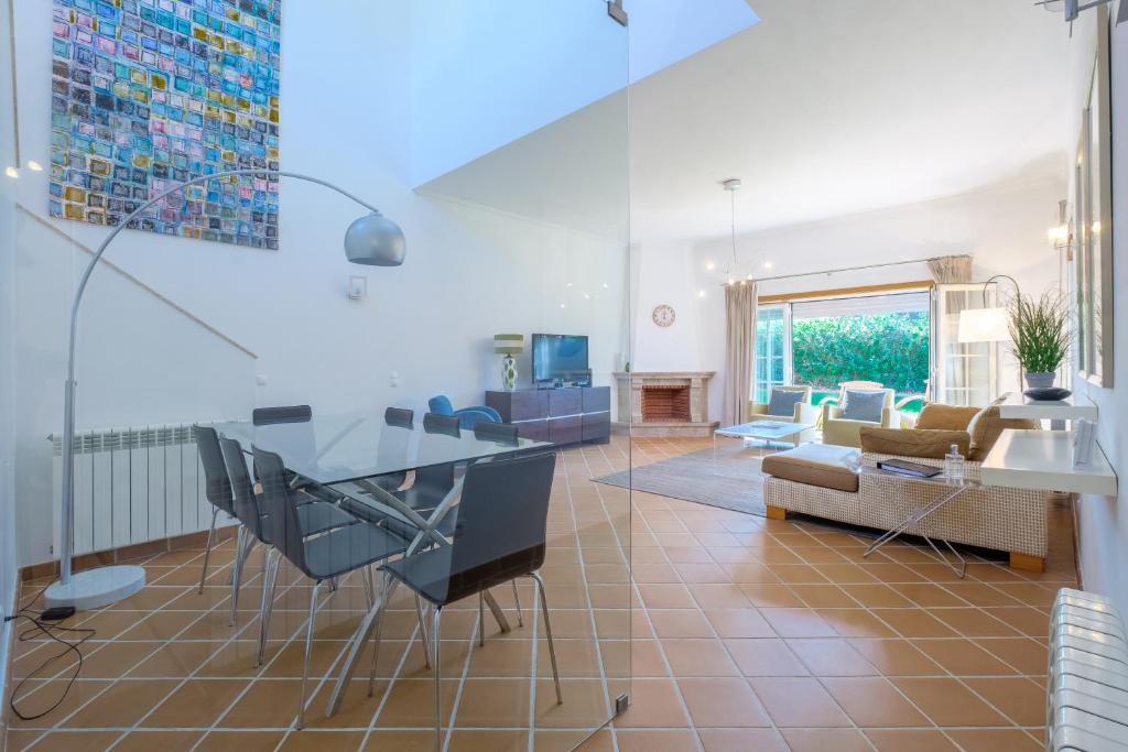 a living room with a glass table and a couch at Principes Townhouse in Casal da Lagoa Seca