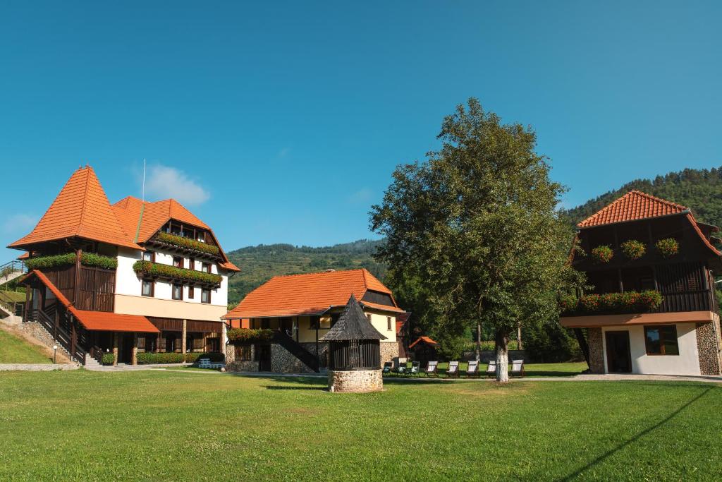 a large building with a red roof on a green field at VILLA GHERMAN in Sălciua de Jos