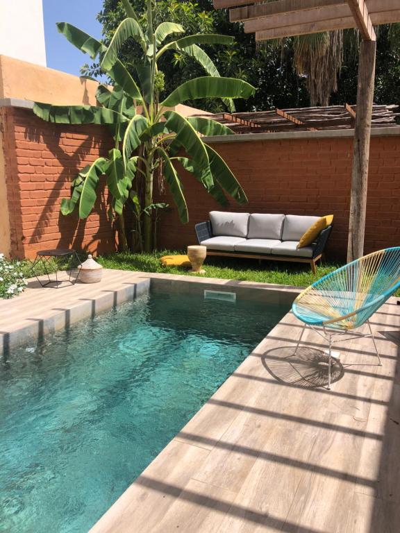 uma piscina com um sofá e cadeiras ao lado de uma casa em BOMA LifeStyle Hotel em Dakar