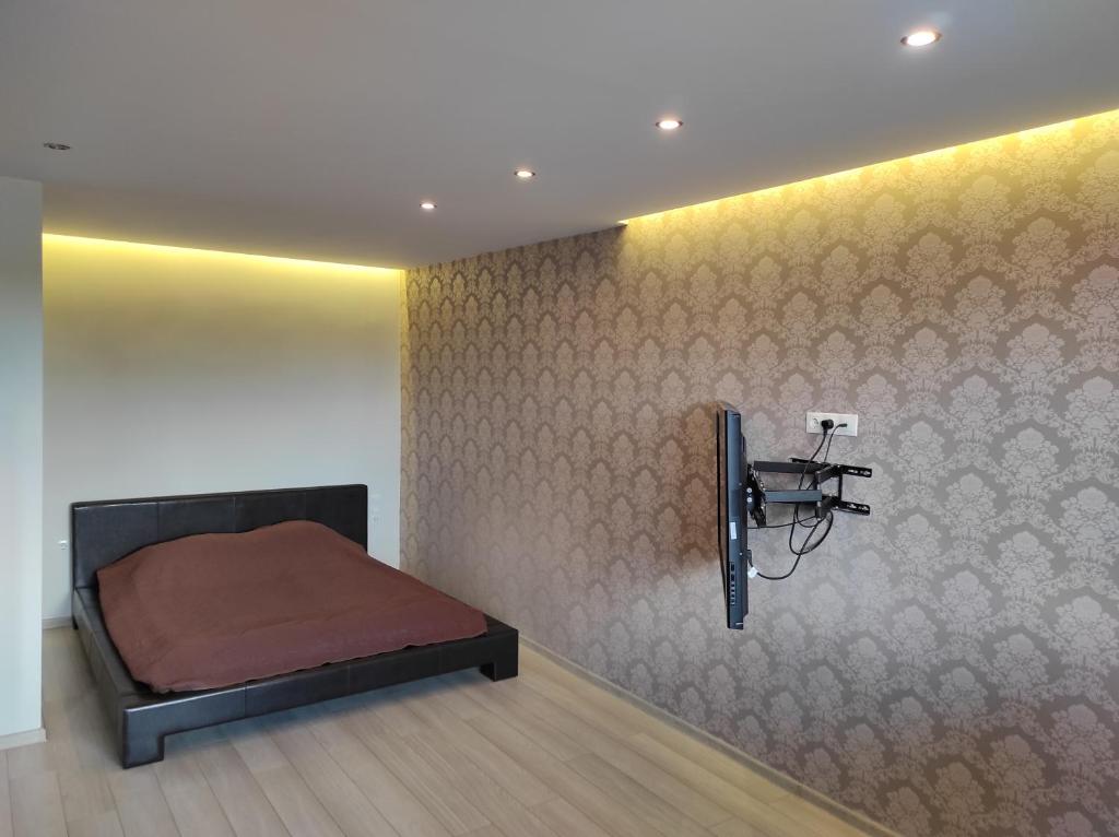une chambre avec un lit et un mur dans l'établissement Studija Centre, à Klaipėda