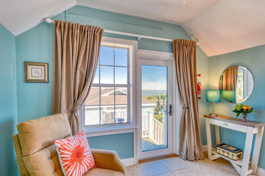 a living room with a chair and a large window at Beachcomber Penthouse in St. Augustine