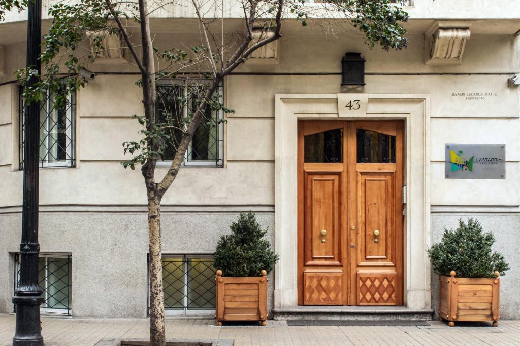 a building with a wooden door and two plants at Lastarria Aparts in Santiago