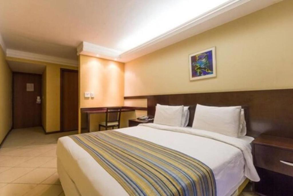 um quarto de hotel com uma cama grande e uma secretária em Plaza Bittar Hotel em Brasília