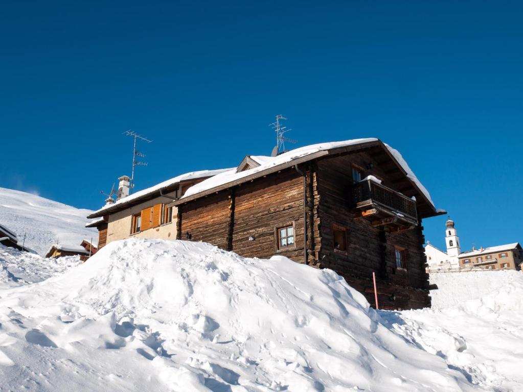 a log cabin with a pile of snow in front of it at Bait Nof - Trepalle in Livigno