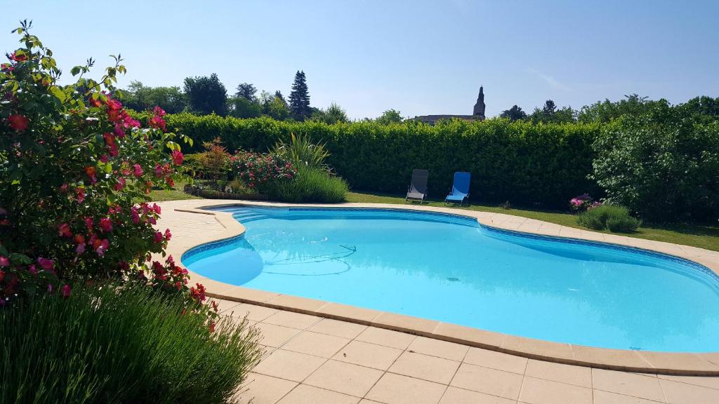 una gran piscina en un patio con flores en Chambres de Sauviolle 2, en Frontenac