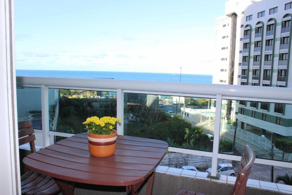 una mesa de madera en un balcón con vistas al océano en Marina Bezerril - 303 Pontamares - O melhor de Natal, en Natal