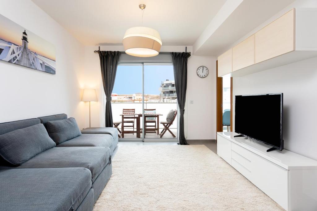 a living room with a couch and a flat screen tv at Tejita beach , The beach dream flats in Granadilla de Abona