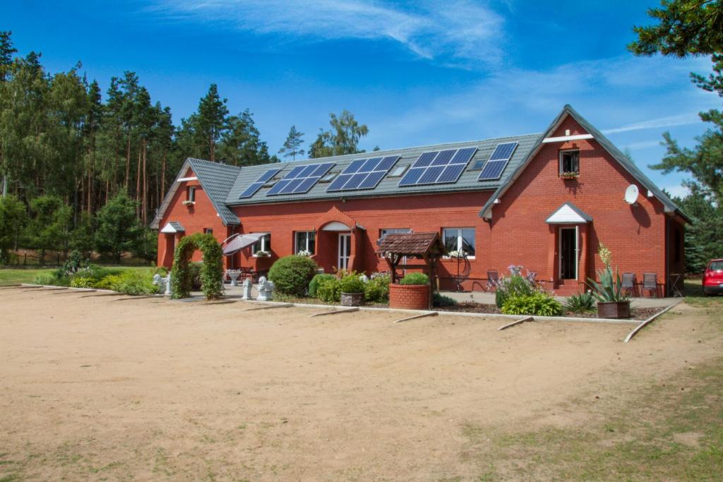 a house with solar panels on the roof at Pensjonat Zakątek in Lidzbark