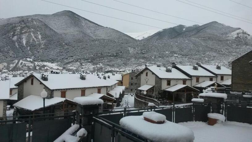 a town covered in snow with mountains in the background at CASA EN VILLANUA in Villanúa