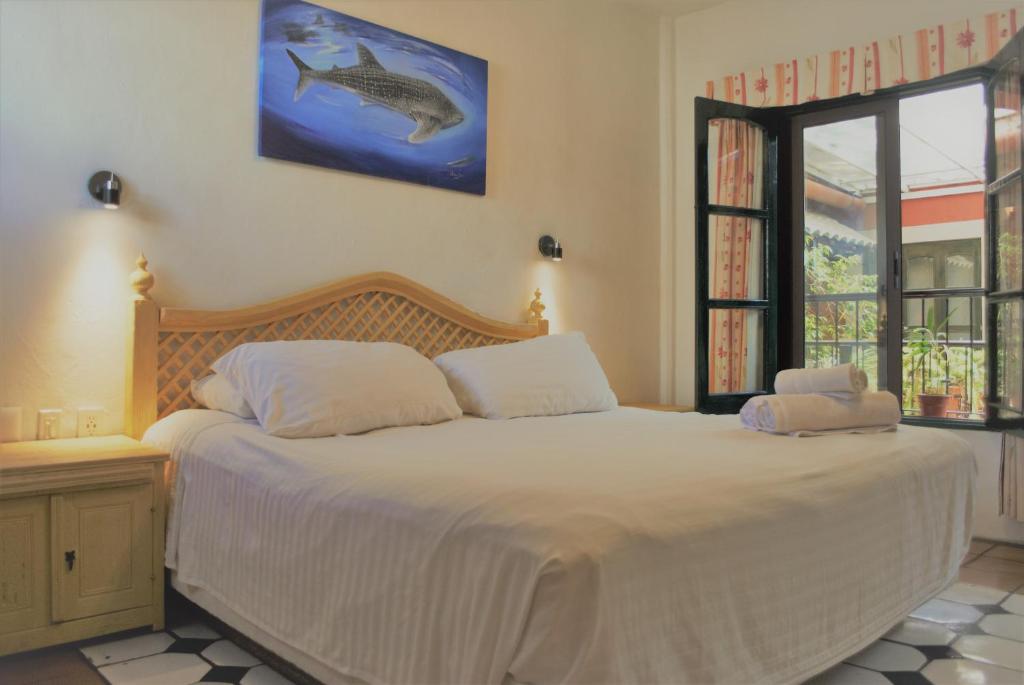 a bedroom with a bed with a fish picture on the wall at Hotel Belmar in Isla Mujeres