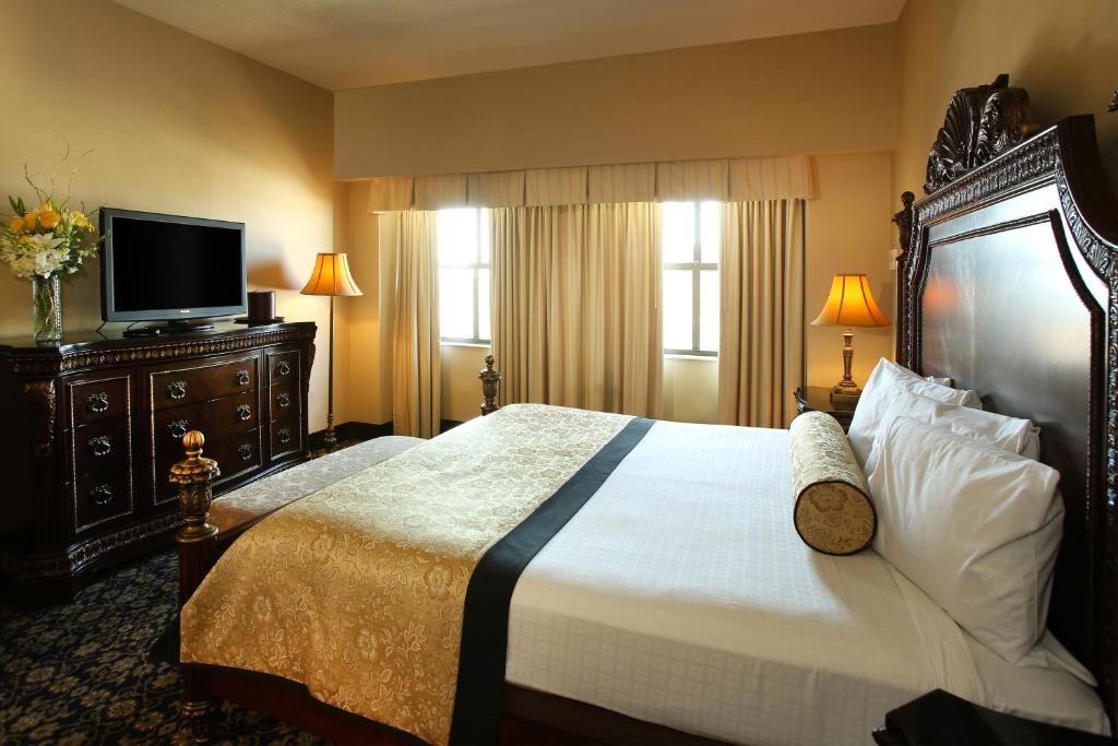 a hotel room with a large bed and a flat screen tv at The Claridge Hotel in Atlantic City
