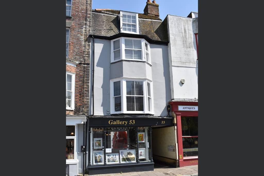 a building on a street with a store at Stunning 18th Century 5 Bed House Old-Town Hastings in Hastings