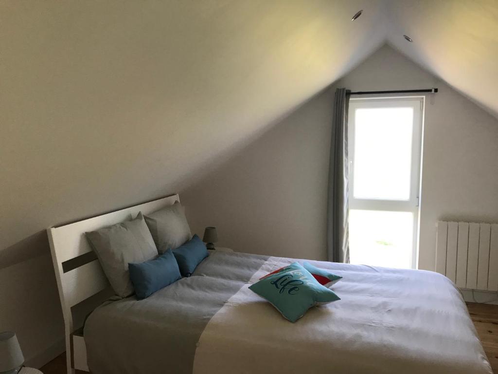 sypialnia z łóżkiem z niebieskimi poduszkami w obiekcie Gîtes des champs & Spa w mieście Bavent