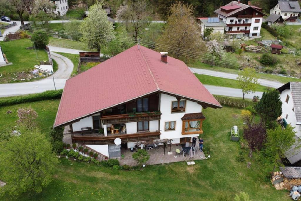 una casa con techo rojo en un campo verde en Ferienhaus Koch Weißbriach en Weissbriach