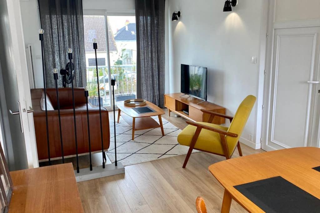 sala de estar con mesa y silla amarilla en Magnifique Appartement Sainte Cécile Plage, en Camiers