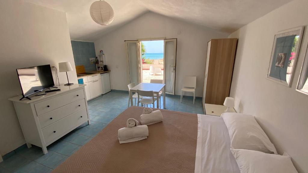1 dormitorio con 1 cama y cocina con mesa en Villa Palma en San Leone