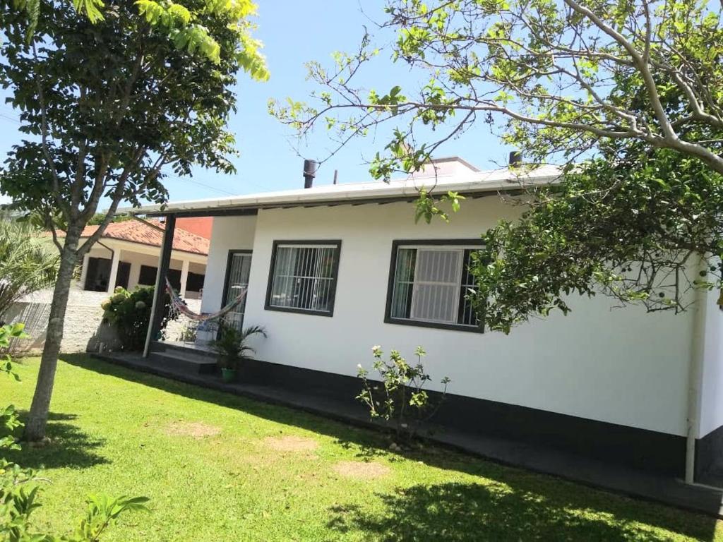 a white house with trees in front of it at Casa de praia na Gamboa - Garopaba SC in Garopaba