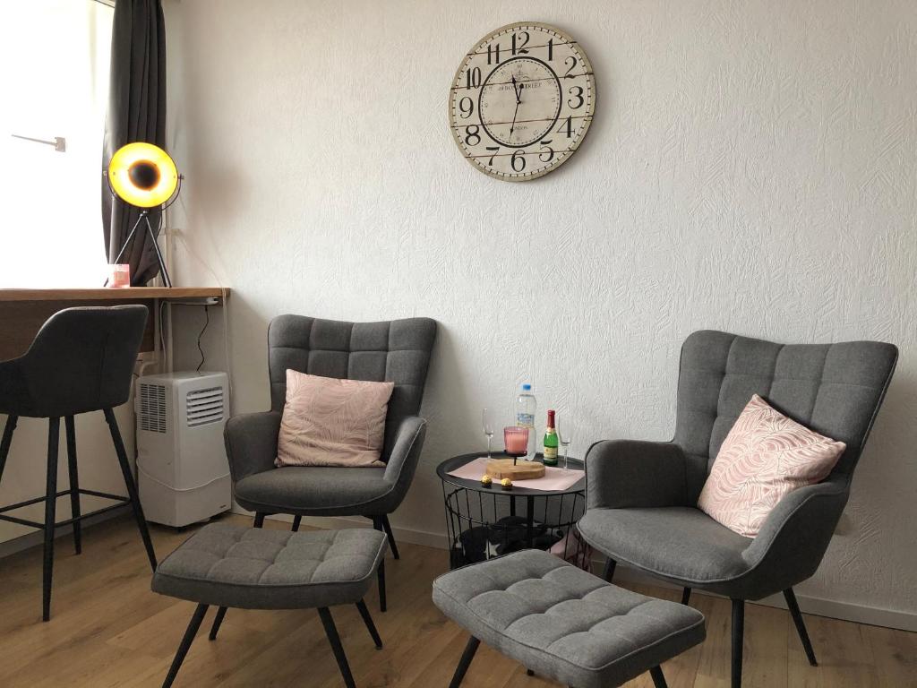 una sala de espera con sillas y un reloj en la pared en Ferienwohnung Rapunzel, en Altenau