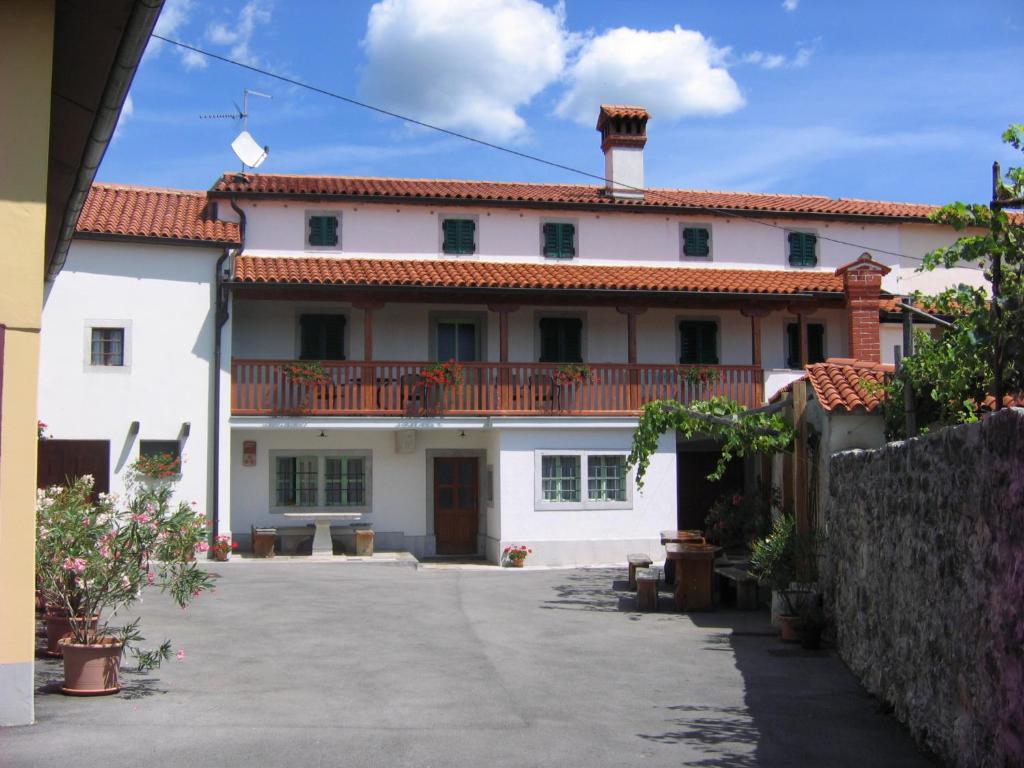 een groot wit huis met een balkon bij Tourist Farm Petelin-Durcik in Pliskovica