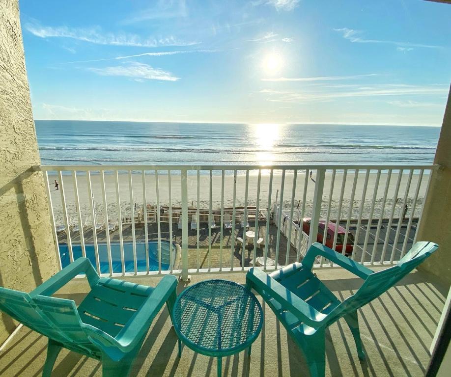balkon z 2 krzesłami i plażą w obiekcie Pirates Cove Resort Studios! w mieście Daytona Beach