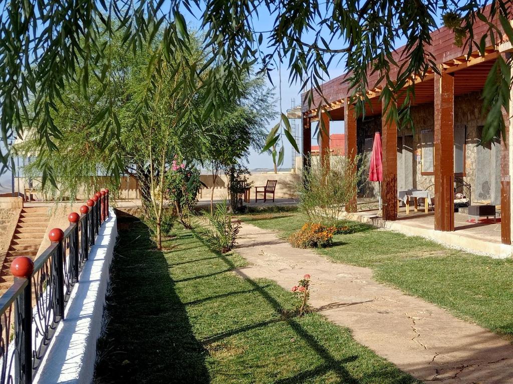 a fence in front of a house with trees at Tamanoucht in Zaouia Ben Smine