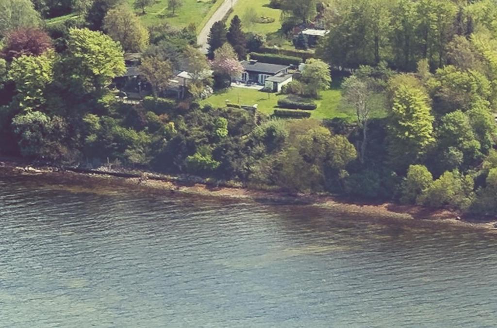 Vue aérienne d'une maison à côté d'une masse d'eau dans l'établissement Traumhaus mit Fördeblick - FÖRDE-ANKER, à Glücksburg