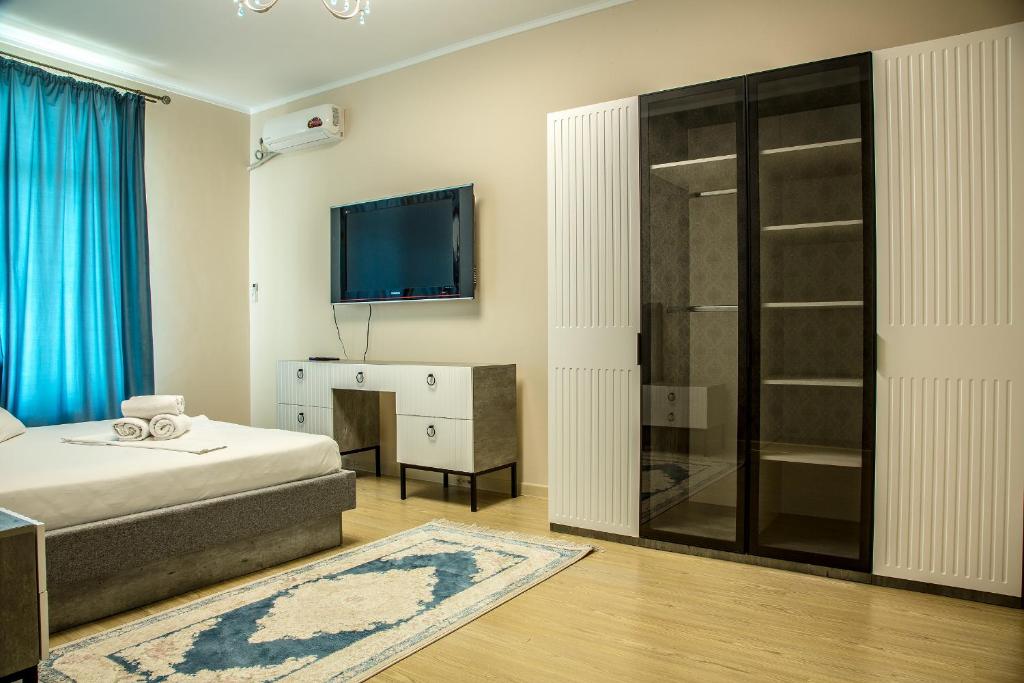 Schlafzimmer mit einem Bett und einem Flachbild-TV in der Unterkunft Апартаменты #89 в ЖК Zaman in Atyrau