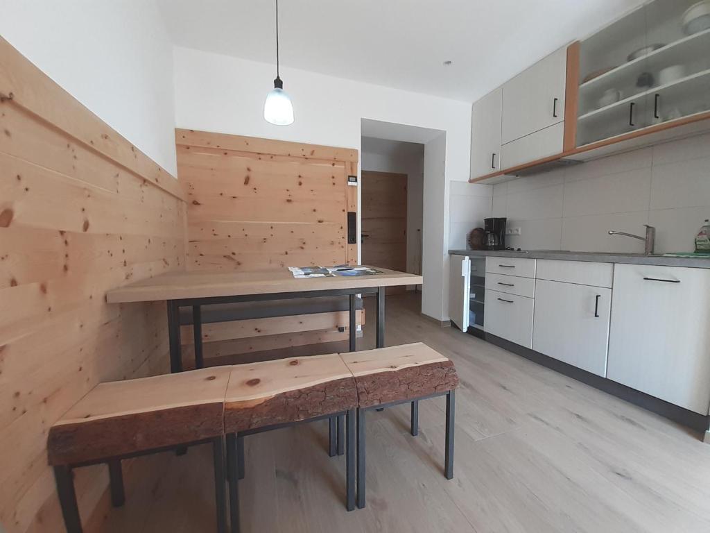 a kitchen with a table and a bench in it at Haus Talblick "Neuräutl" Ferienwohnung 2 in Naturno