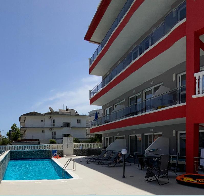 a hotel with a swimming pool next to a building at Princess Luxury Suite in Paralia Katerinis