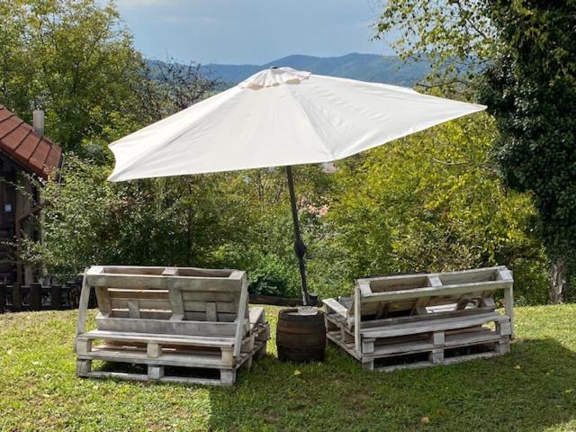 ein weißer Regenschirm und zwei Stühle unter einem Tisch in der Unterkunft Studio apartman "DJED" in Hrvatska Kostajnica