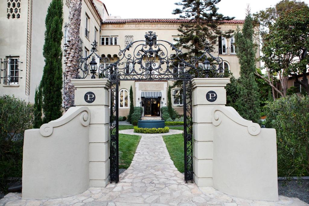 an ornate gate to a mansion with a fountain at Palihouse Santa Monica in Los Angeles