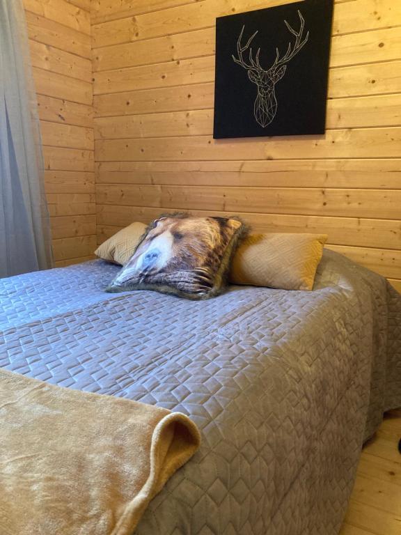 Cama en habitación con pared de madera en Asplunda Gård, Kolmården, stuga nr 3 en Kolmården